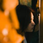 Young woman looking out a window at night